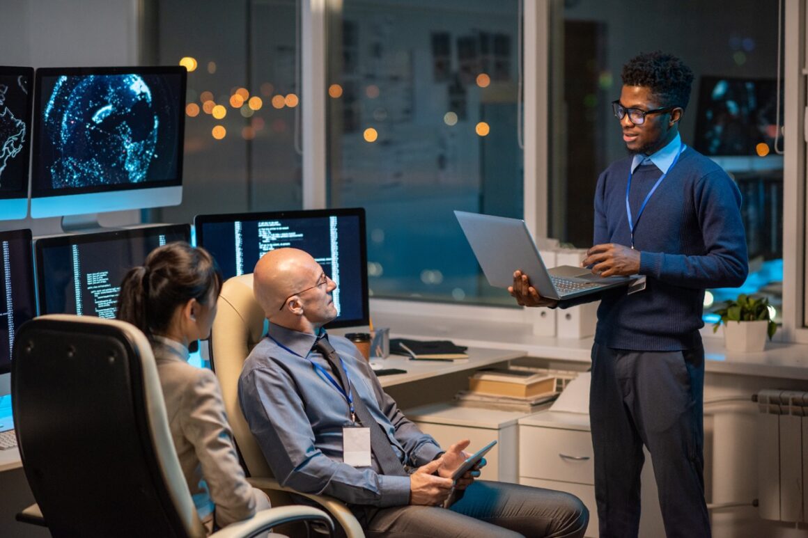 Young successful businessman with laptop making presentation for colleagues Digital Transformation for UAE Healthcare Facilities