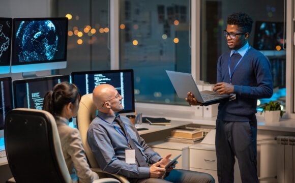 Young successful businessman with laptop making presentation for colleagues Digital Transformation for UAE Healthcare Facilities